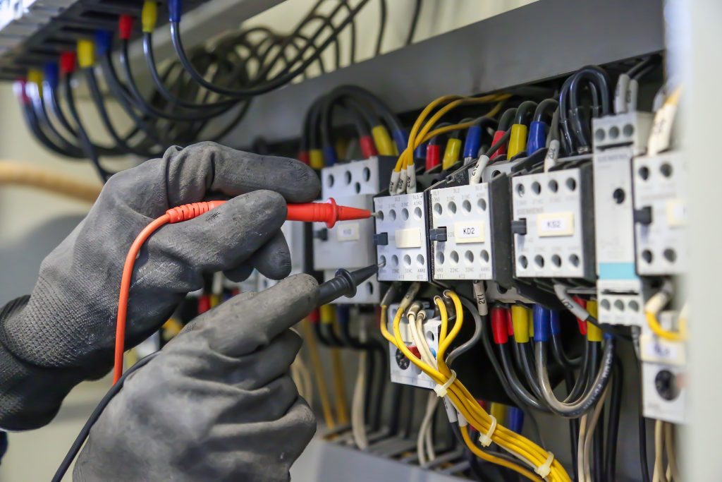 elektrotechniker verwendet digitales messgeraet zur ueberpruefung der elektrischen stromspannung am leistungsschalter 1 | AB Prüfservice