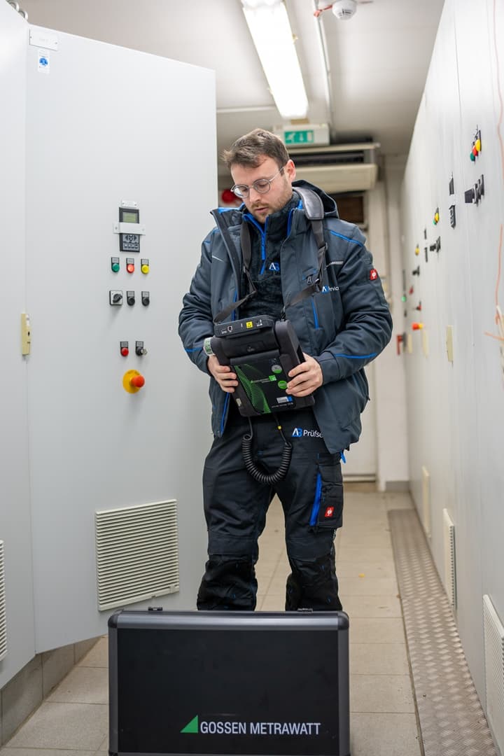 Ein Mann in einer blauen Jacke steht in einem Flur.